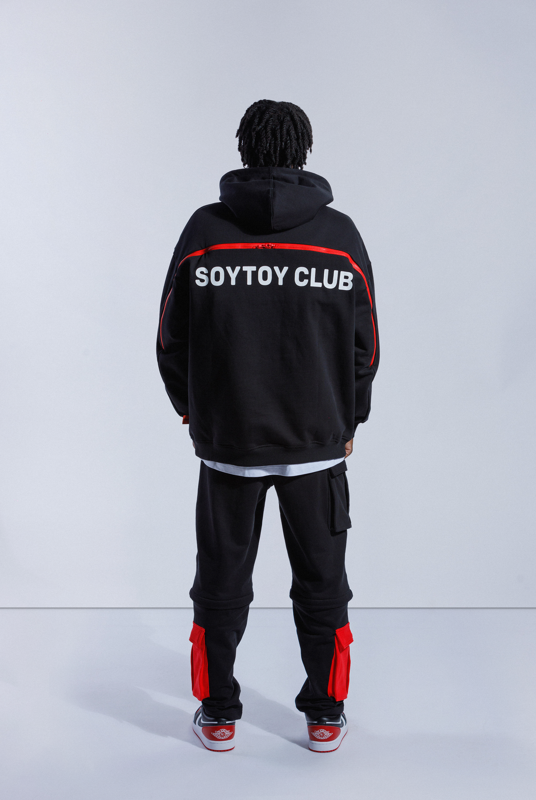 Back of model wearing 2 Wayz Hoodie. Large red zipper is undone across the back, showing inside - A red panel with Astro Boy falling
