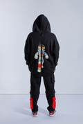 Back of model wearing Black Astro Boy zip hoodie with hood up, with large black zip down the middle and Astro Boy graphic showing his internal mechanism
