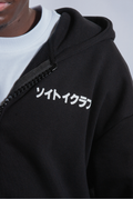Close up of front of black Astro Boy zip hoodie with white text on left chest. Japanese text that reads SOYTOY CLUB