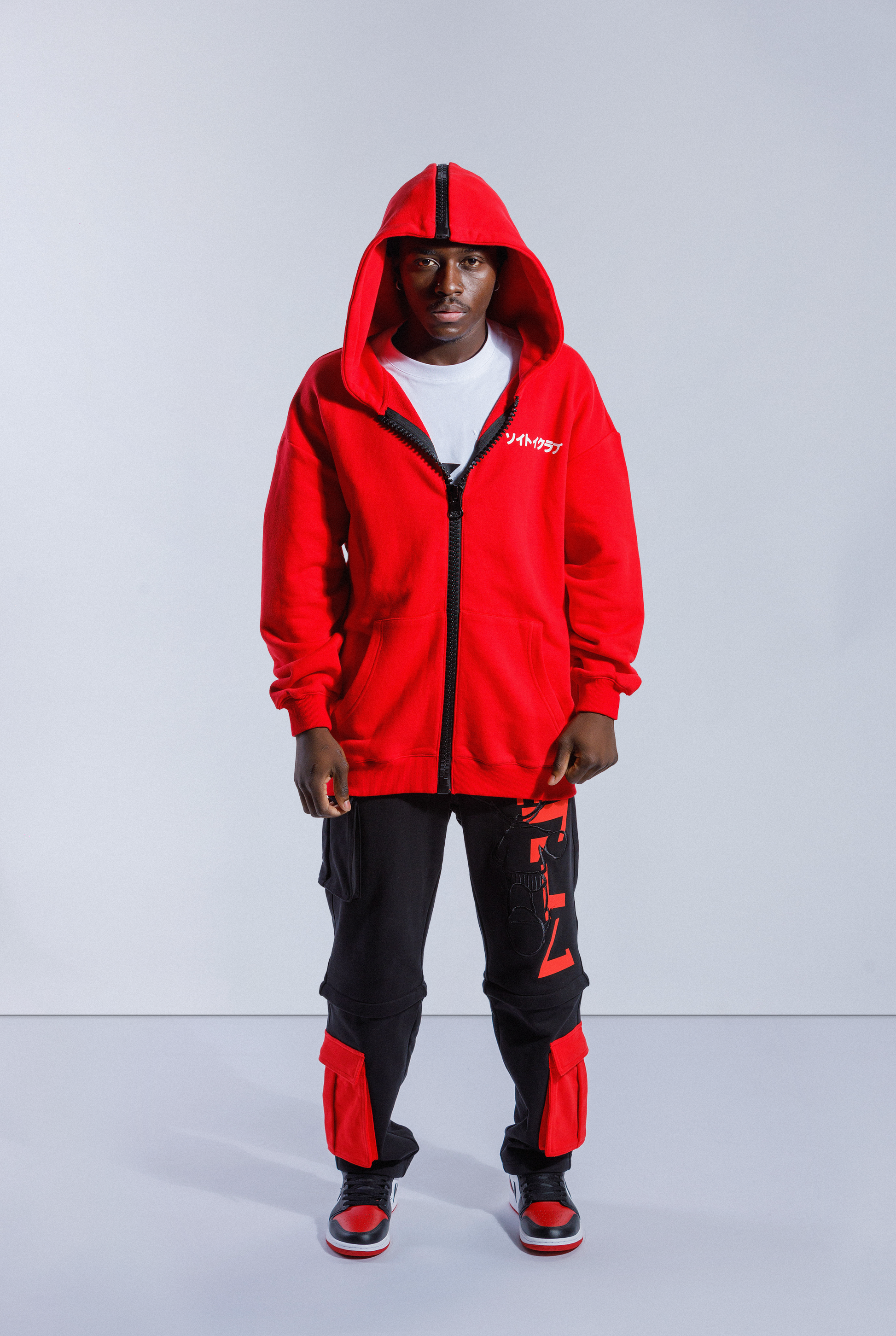 Model wearing Red Astro Boy zip hoodie with large black zip down the middle and hood up