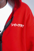 Close up of front of Red Astro Boy zip hoodie with white text on left chest. Japanese text that reads SOYTOY CLUB