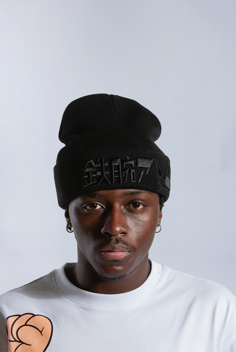 Model wearing black Astro Boy beanie with embroidered Japanese text that reads 'ATOM BOY' - The original Astro Boy Logo