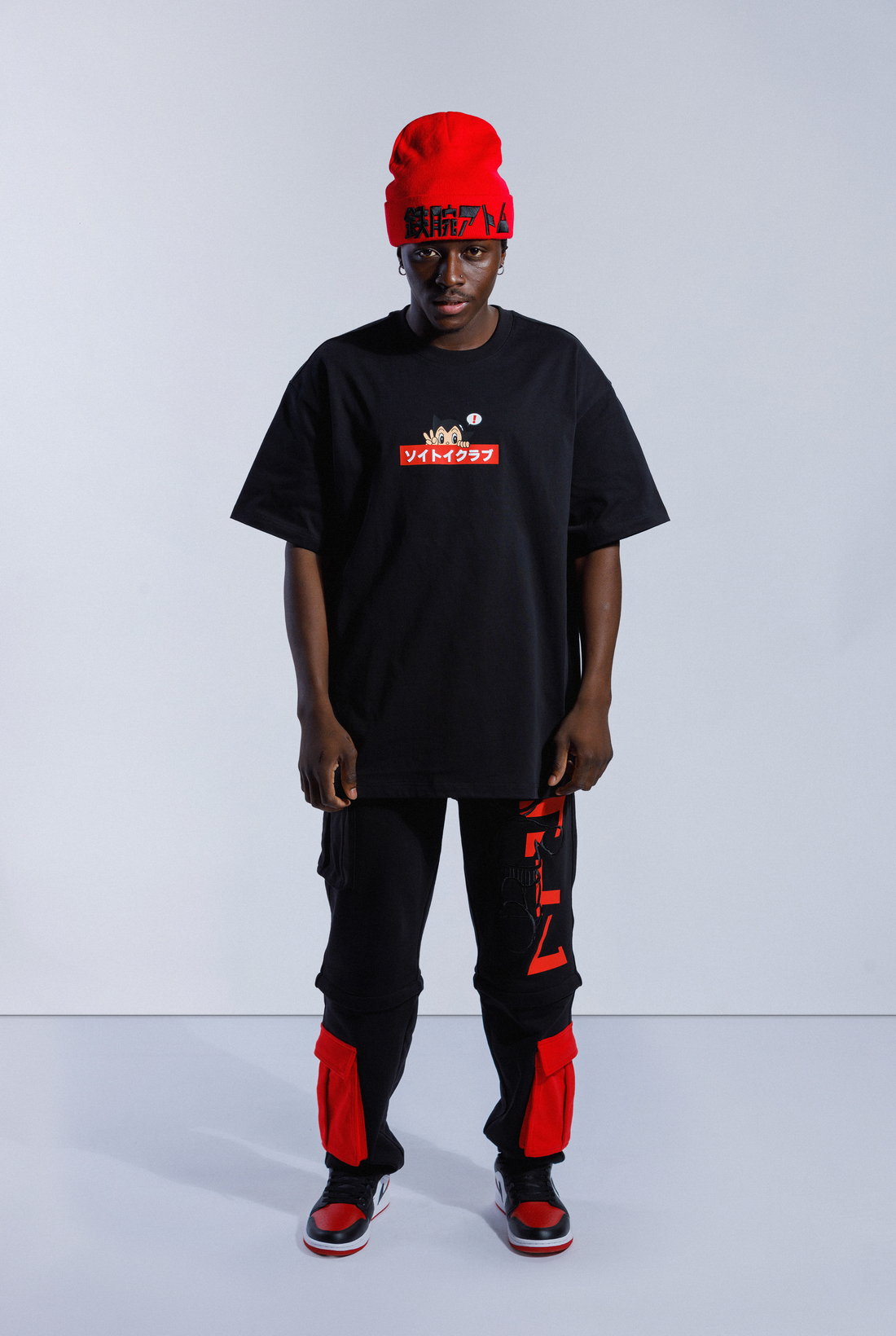 Model wearing black Astro Boy OG Box Logo tee. Tee has red box with Japanese 'SOYTOY CLUB' embroidered on the front with Astro Boy on top