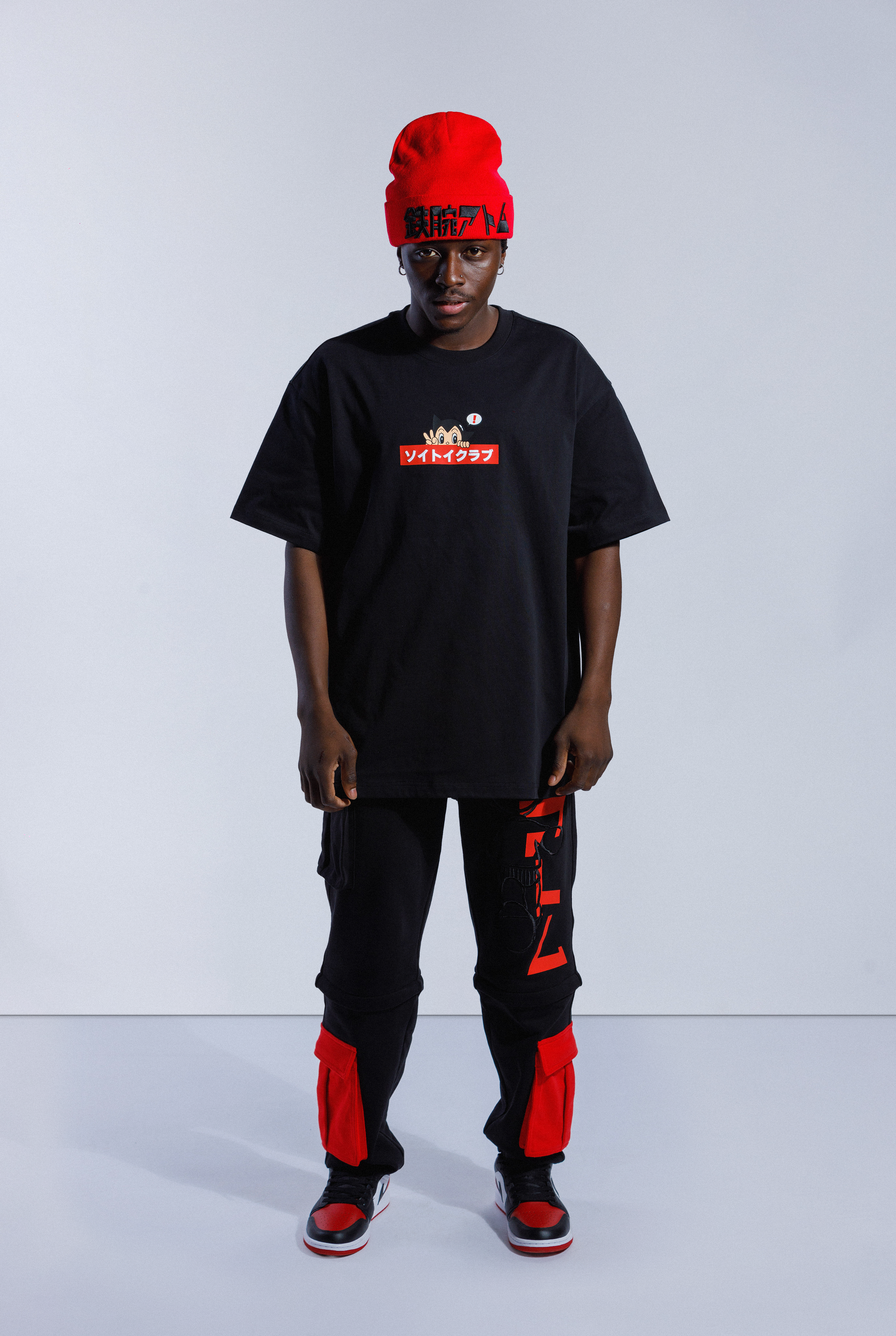 Model wearing black Astro Boy OG Box Logo tee. Tee has red box with Japanese 'SOYTOY CLUB' embroidered on the front with Astro Boy on top