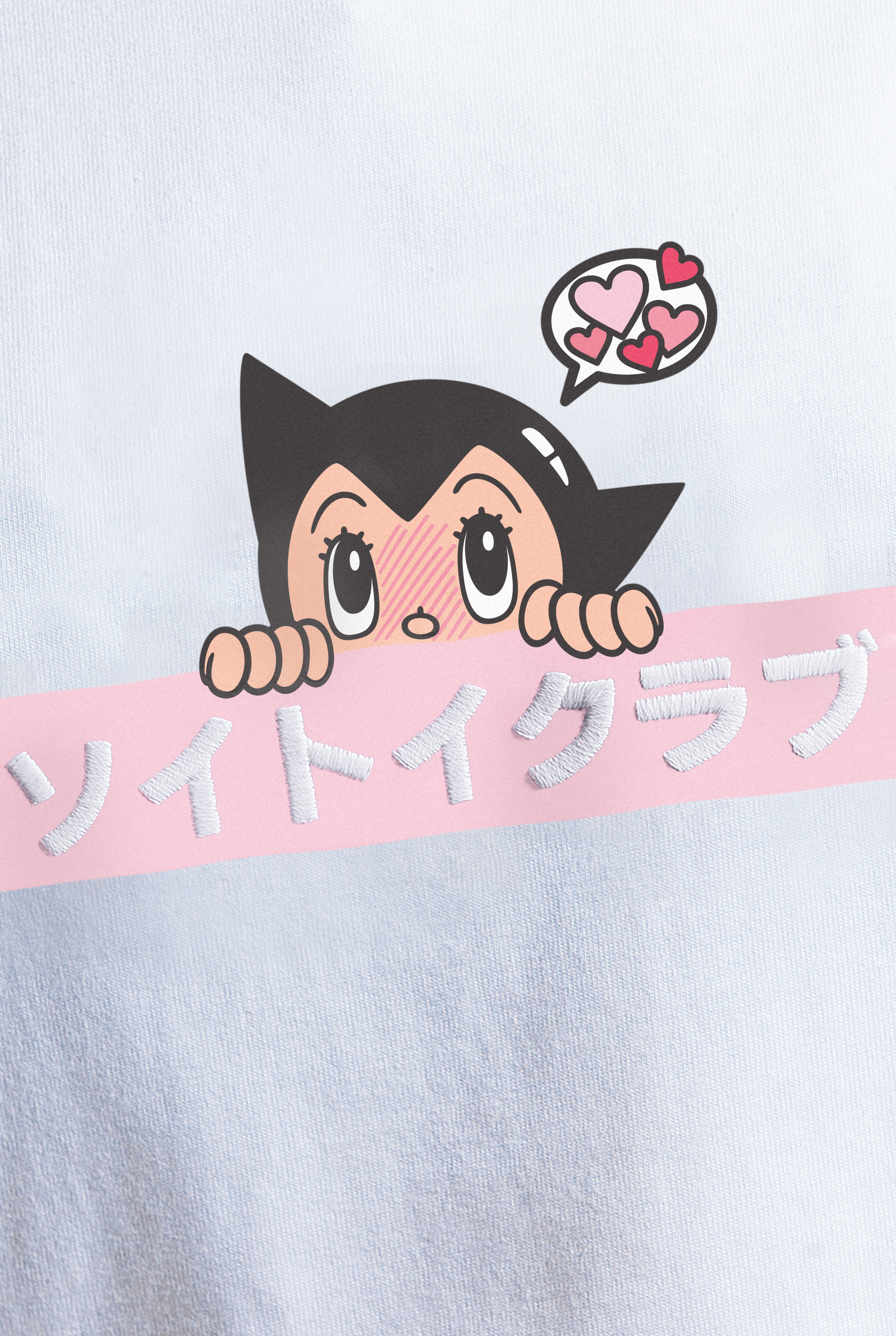 Close up of Astro Boy Love Box Logo tee. Tee has pink box with Japanese 'SOYTOY CLUB' embroidered on the front with Astro Boy on top