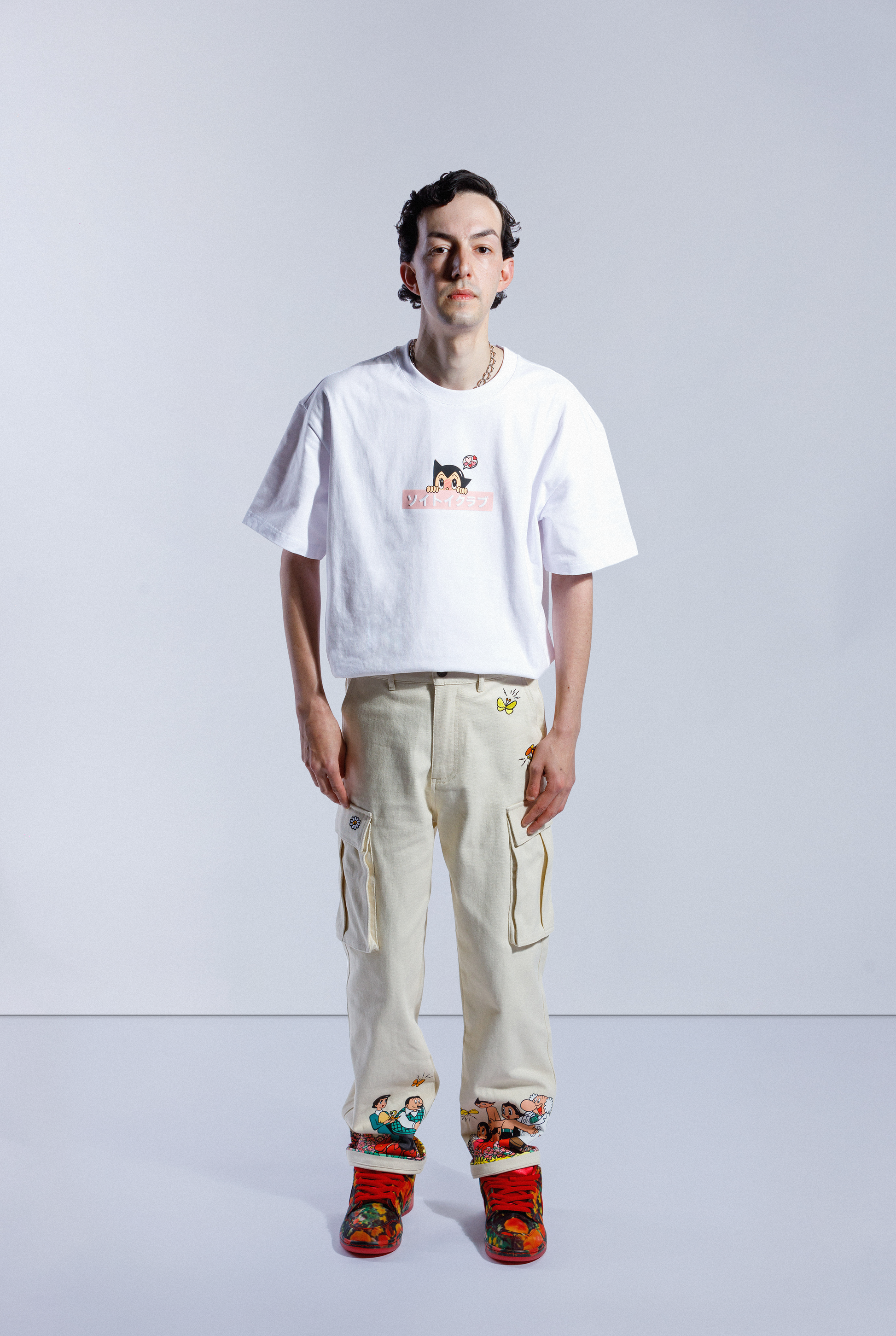 Model wearing white Astro Boy Love Box Logo tee. Tee has pink box with Japanese 'SOYTOY CLUB' embroidered on the front with Astro Boy on top
