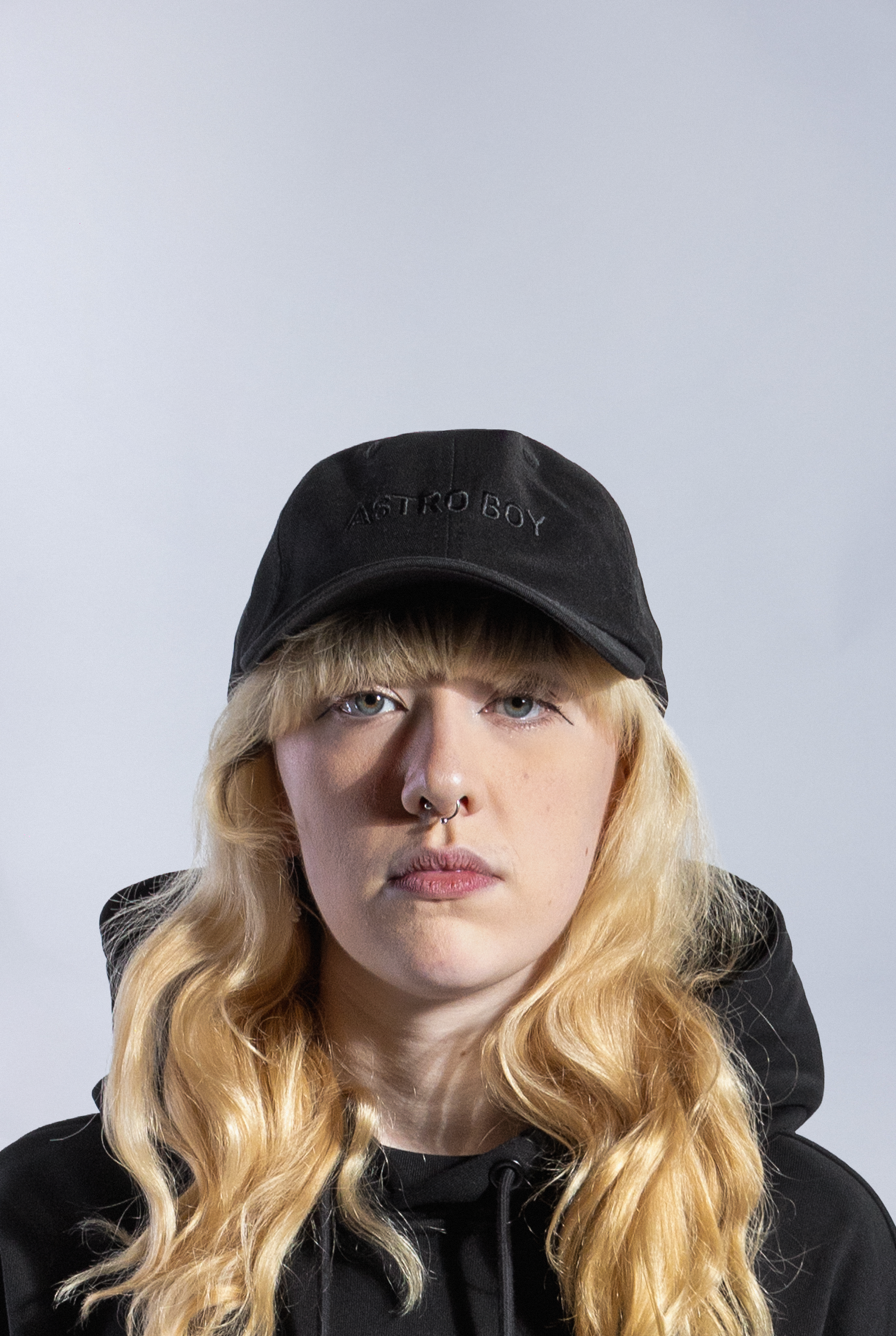 Model wearing Black Astro Boy Cap with embroidered monochromatic Astro Boy text