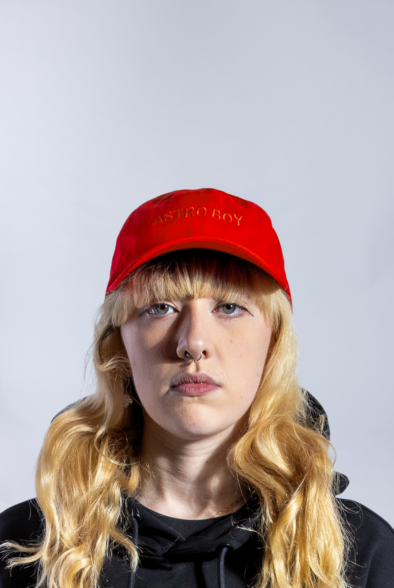 Model wearing Red Astro Boy Cap with embroidered monochromatic Astro Boy text