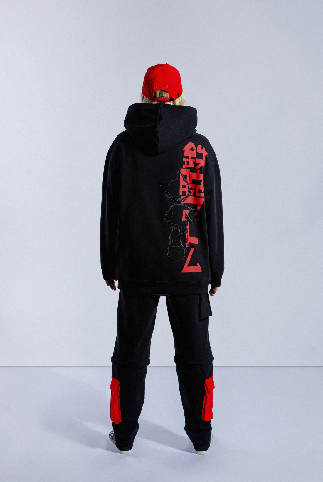Back of model wearing black Astro Boy End Credits hoodie. Large red Astro Boy text in Japanese with an embroidered Astro Boy silhouette over the top