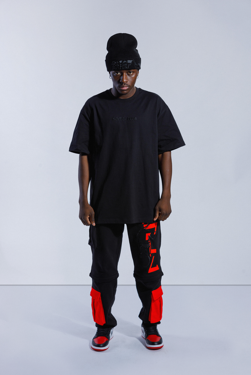 Model wearing black Astro Boy End Credits tee. Tee has black 'SOYTOY CLUB' embroidered on the front