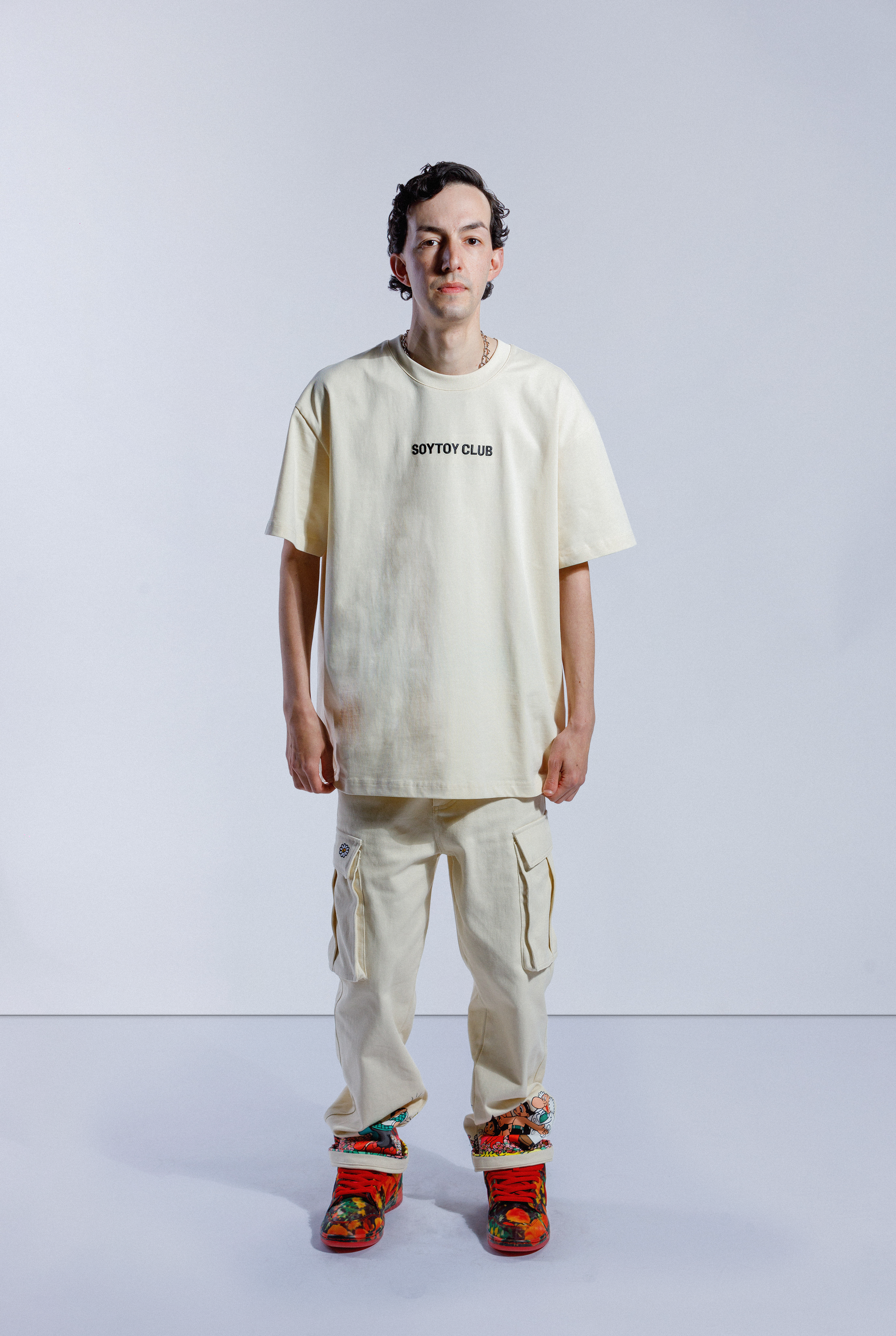 Model wearing cream Astro Boy End Credits tee. Tee has black 'SOYTOY CLUB' embroidered on the front
