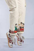 Cream Astro Boy Jeans with screen printed graphic wrap around the bottom of both pant legs. Graphic shows Astro Boy and his family in a field of flowers