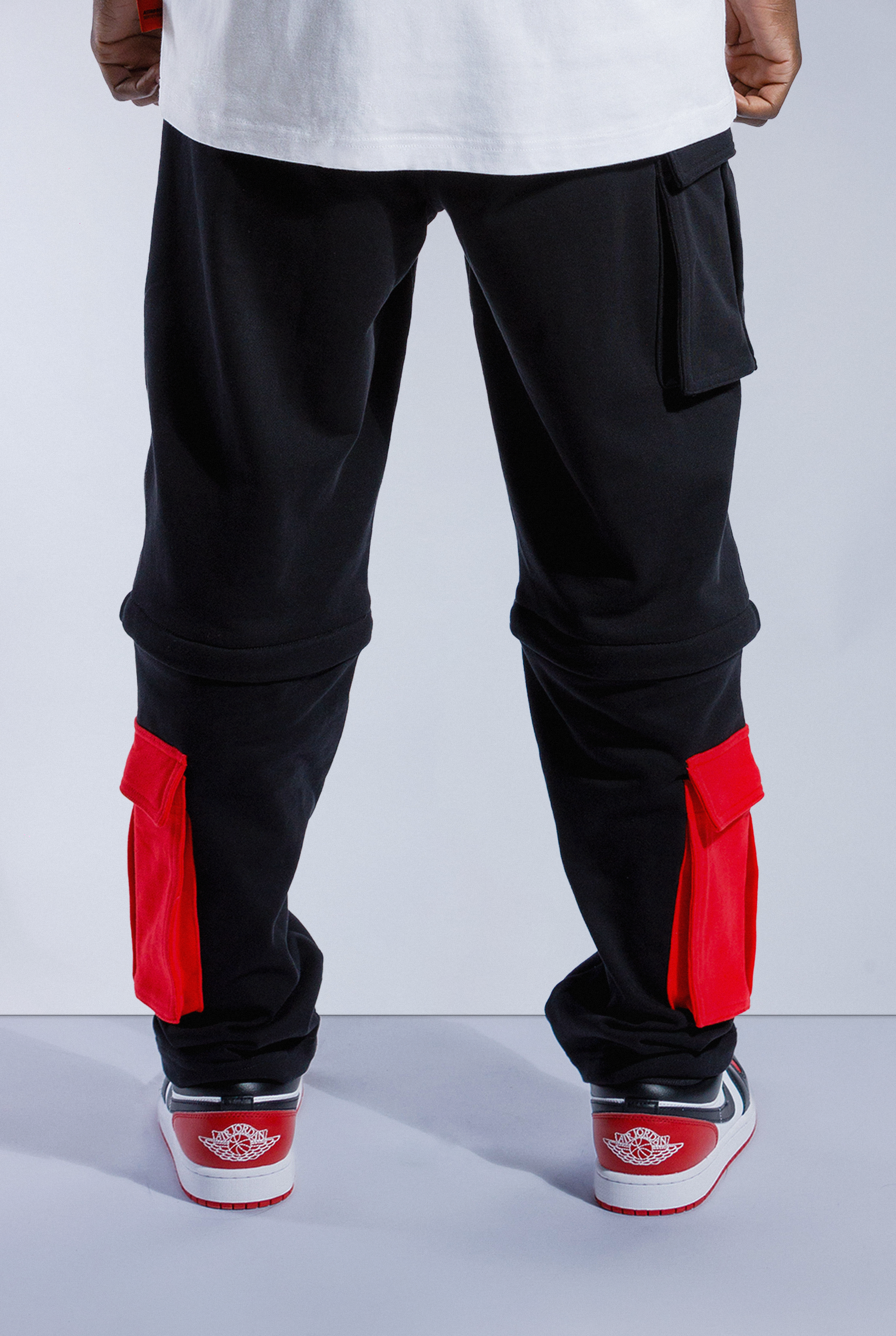 Back of black and red Astro Boy Trackpants. Has zipper at knee to turn into shorts