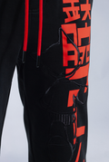 Close up of Astro Boy trackpants. Shows red screenprint logo, black embroidered astro boy logo and red drawstrings