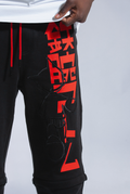 Close up of Astro Boy trackpants. Shows red screenprint logo, black embroidered astro boy logo and red drawstrings