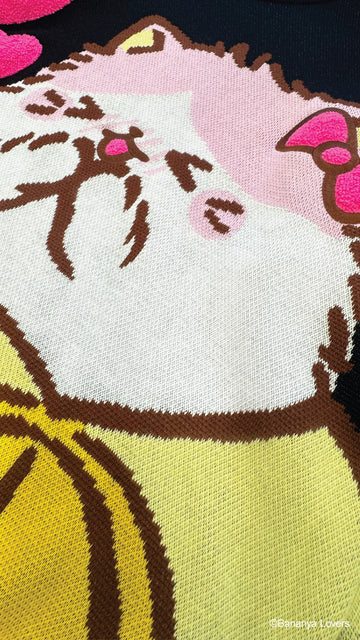 Close up of black knit Bananya sweater. shows knit detail and raised fluffy bow and hearts on design