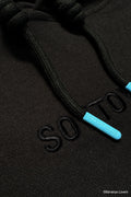 Close-up of a black hoodie with blue 'Soytoy club' aglets