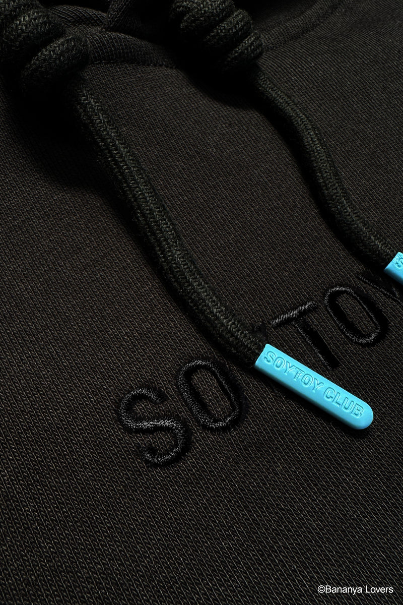 Close-up of a black hoodie with blue 'Soytoy club' aglets