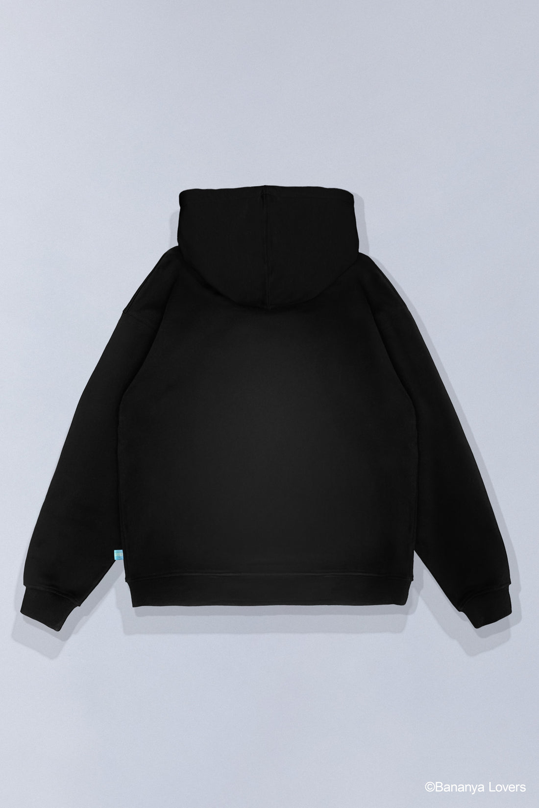 Black SOYTOY CLUB hoodie featuring Bananya the white cartoon cat sitting inside a yellow banana on a light gray background