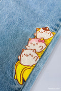Close up of embroidered detail showing Bananya cat, Bananyako cat and Mike Bananya stacked on top of each other
