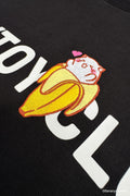 Detail of black Bananya Logo t-shirt. Shows white 'SOYTOY CLUB' text with embroidered Bananya cat on top.