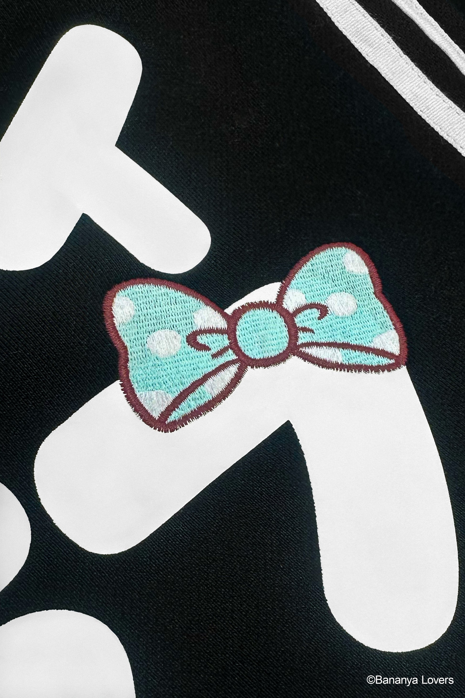 Detail shot of Bananyako Seifuku showing back of sailor flap with text that reads 'SOYTOY CLUB' and an embroidered blue Taremimi Bananya bow