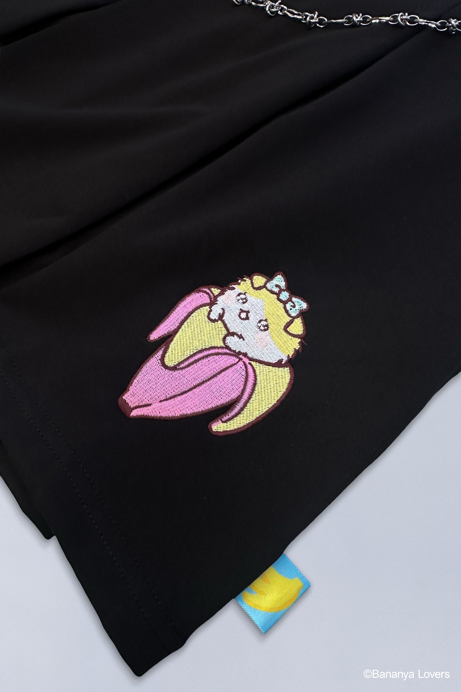 Close up of embroidered Taremimi Bananya design on black skirt