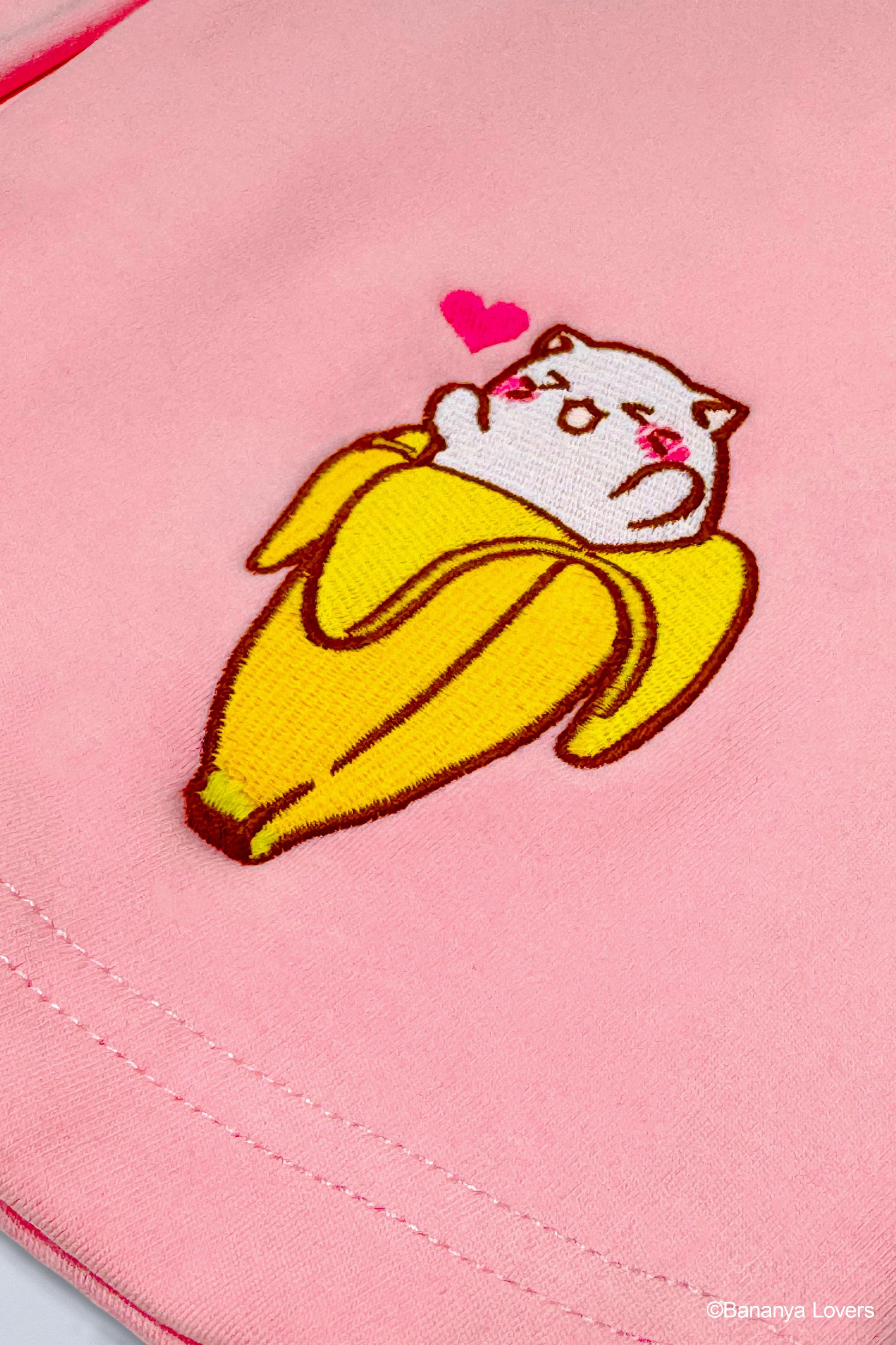 Close up of embroidered Bananya design on pink skirt